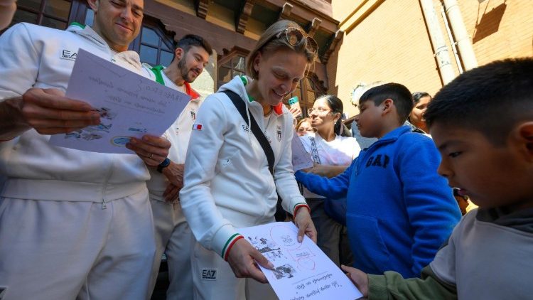 Gli atleti olimpici ricevono i disegni dei bambini. 