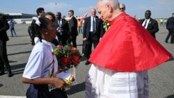 2026.04.18 Mtoto akimkaribisha Papa kwa maua mara baada ya kufika Angola.