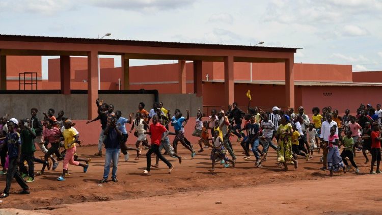 Ragazzi che corrono affiancando la papamobile