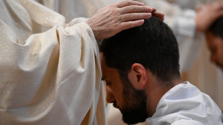 Le mani di un sacerdote sul capo dell'ordinando