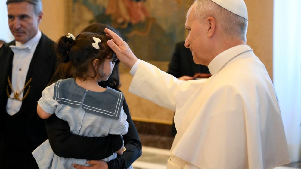 Il Papa accarezza una bambina durante l'udienza ai membri della Fondazione Edith Haberland-Wagner e dell’Augustiner Bräu di Monaco