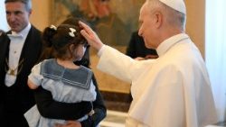Il Papa accarezza una bambina durante l'udienza ai membri della Fondazione Edith Haberland-Wagner e dell’Augustiner Bräu di Monaco