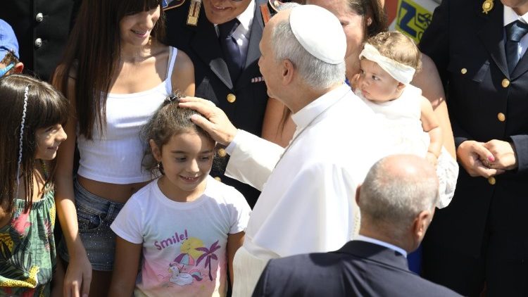 Leone XIV mentre benedice una bambina