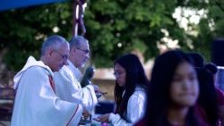 Le cardinal Pierbattista Pizzaballa et l'évêque Rafic Nahra administrent la Sainte Communion à des jeunes lors du Festival de la jeunesse à Deir Rafat.