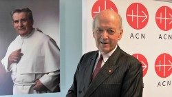 Heine-Geldern vor einem Foto des „Speckpaters“ Werenfried van Straaten, der „Kirche in Not“ gründete