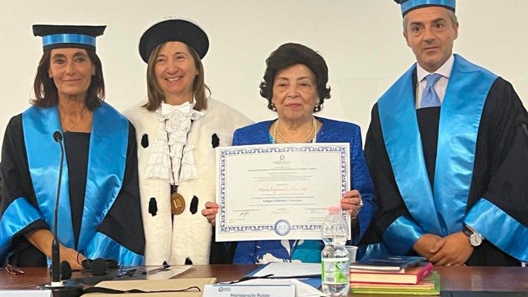 Maria Eugenia Neto exibindo o título de Doutora Honoris Causa