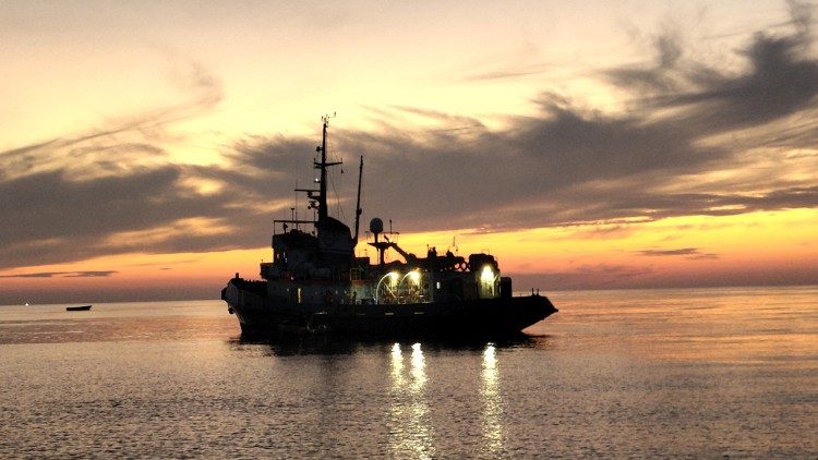 The Mare Jonio with, in the background, an empty migrant boat