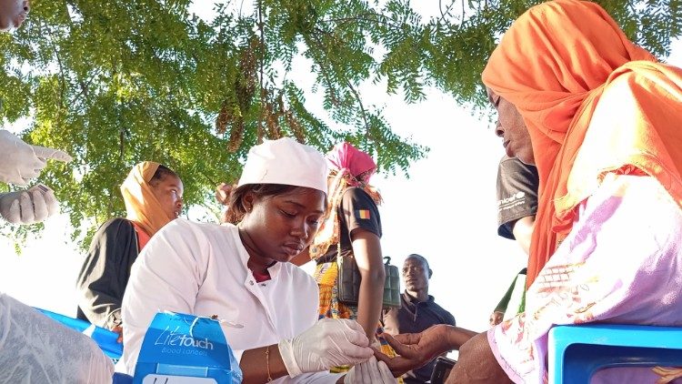 Un membre de l'équipe de l'UCAAC avec un patient.