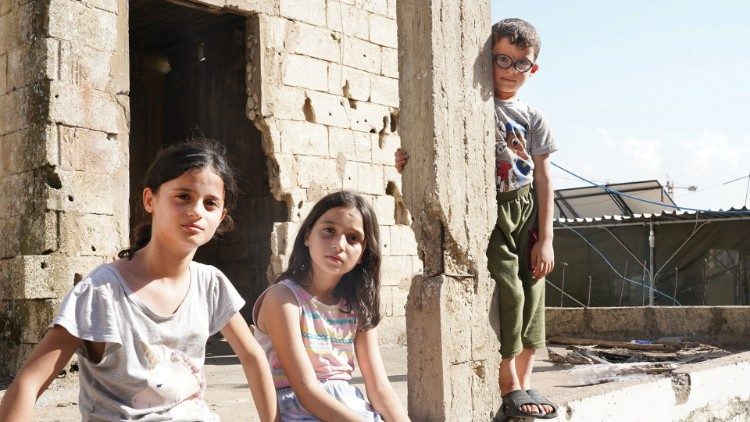 Children gather in a rundown section of the camp. Photo: Raghida Skaff - CNEWA