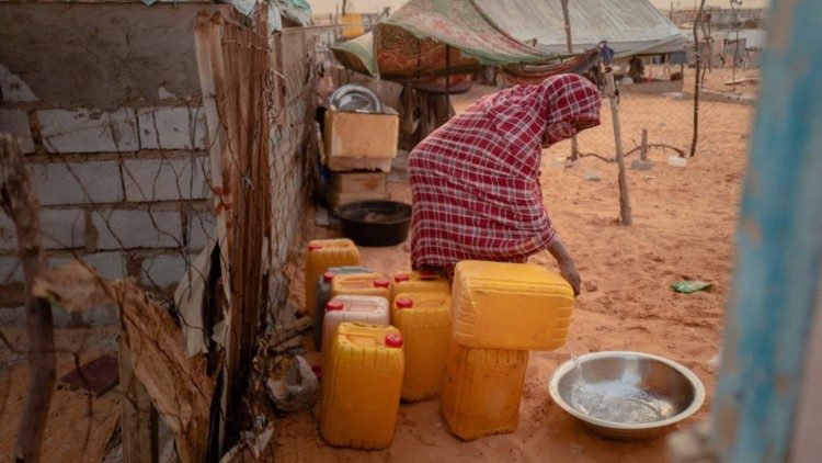 Una donna di Tarhil versa acqua da una tanica (foto: Michele Cattani/Afp)