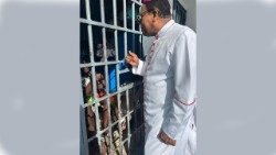 Monsignor Dumas durante una visita ai carcerati di Haiti prima dell'attentato (Foto d'archivio)