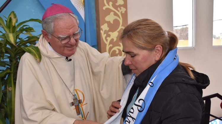 Monseigneur Oscar Ojea remet une écharpe aux couleurs du drapeau argentin à l'une des cuisinières des soupes populaires, comme symbole d'unité et de fraternité.