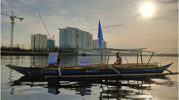 Un pêcheur dans la baie de Manille devant des constructions en cours. 