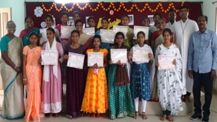 Young girls are awarded certificates for completing their vocational training in Computer Basics