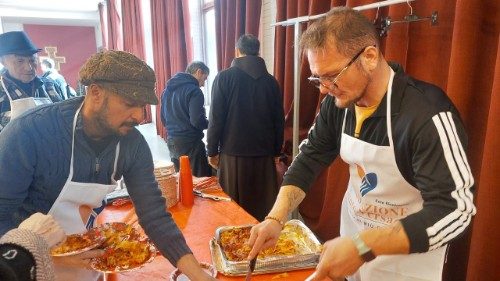Ciro impiatta le lasagne nel pranzo offerto ai poveri nei locali della parrocchia di via Gregorio VII