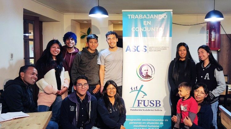 Giovani migranti. Sullo sfondo lo slogan "Al lavoro insieme"