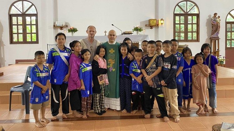 Le père Alessandro Brai avec plusieurs enfants. 