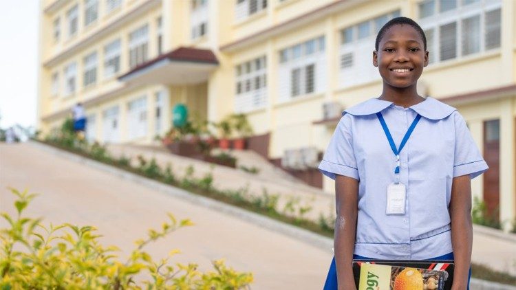 किसरवे गर्ल्स टाउन के संत मेरी स्कूल में एक छात्रा अपनी किताबें दिखाती हुई)