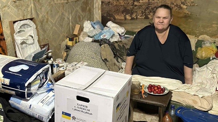 Žena přeb&iacute;r&aacute; bal&iacute;ček s potravinami, dar od papeže, ve sv&eacute;m domě