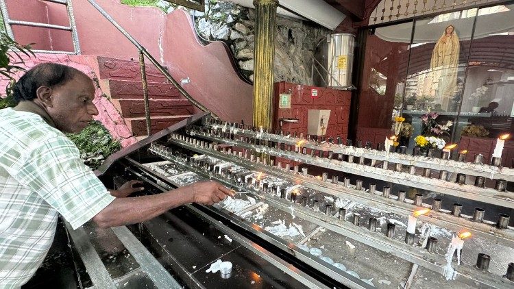 Selvanathan, a volunteer from St Anthony's Church, collects wax to be recycled