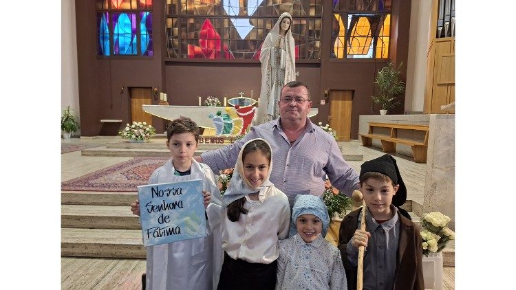 Pessoas em oração à passagem do andor de Nossa Senhora