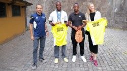 Olympic champion Letsile Tebogo (center), holding an Athletica Vaticana t-shirt