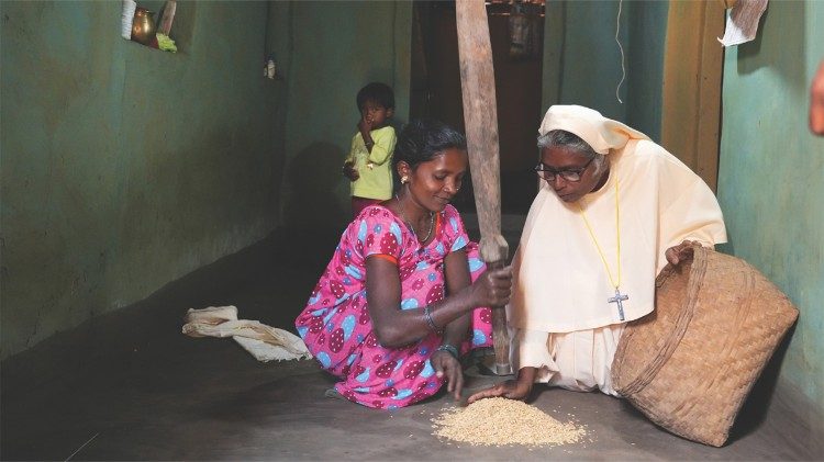 Sister Sincy Thomas of the Snehagiri Missionary Sisters husks rice with a tribal woman in Koleng, a village in Chhattisgarh state. (Photo: Sajeendran V.S. - CNEWA)