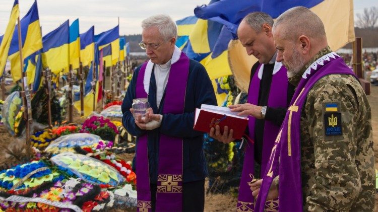 Отець Томаж зі співбратами моляться на цвинтарі