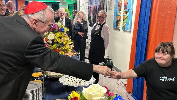Il cardinale Parolin saluta una ragazza, collaboratrice di Merè, una "merenderia" che a Roma occupa ragazzi disabili per servizi di catering.