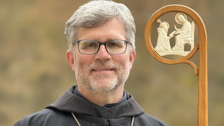 Abt Mauritius Wilde mit dem Abtstab. Im Zentrum des Stabes steht eine Elfenbeinschnitzerei. Sie zeigt Jesus Christus, der dem knienden Benedikt das Evangelium übergibt.