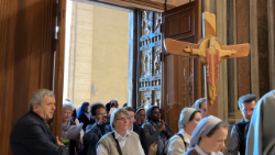 Un grup de pelerini trecând pragul Porții Sfinte a bazilicii San Pietro