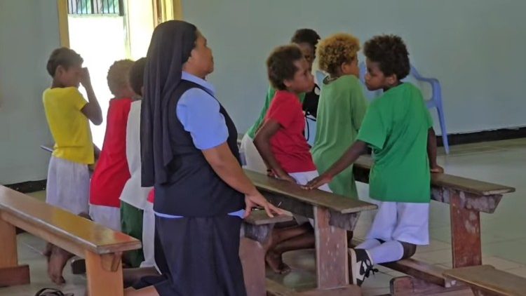 ילדים מהבית הספר הסמוך מתפללים בקפלה על שם פיטר טו רוט, יחד עם האחות דייזי