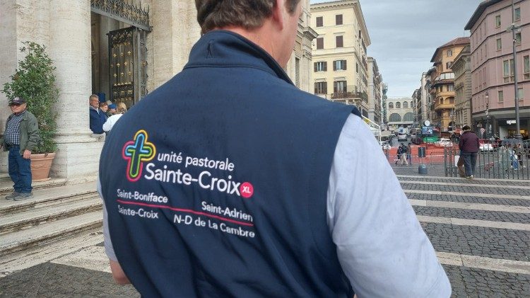 Padre Emmanuel mostra il suo gilet con il nome delle parrocchie in pellegrinaggio giubilare