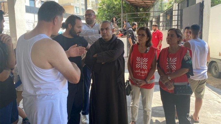 In der Mitte des Fotos unterhält sich der Präsident der Caritas Libanon, Pater Michel Abboud, mit Mitarbeitern und Begünstigten der Caritas.   (Caritas Libanon)