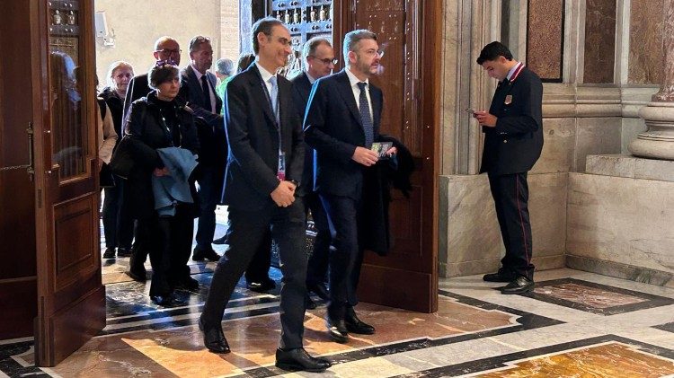 Fedeli attraversano la Porta Santa dopo l'udienza con il Papa in piazza San Pietro.
