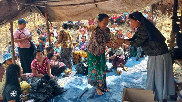 Uma freira birmanesa distribui alimentos em um campo de refugiados.