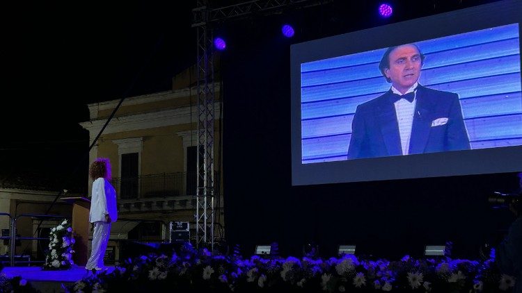 Manuela Villa e un'immagine di Pippo Baudo sullo schermo