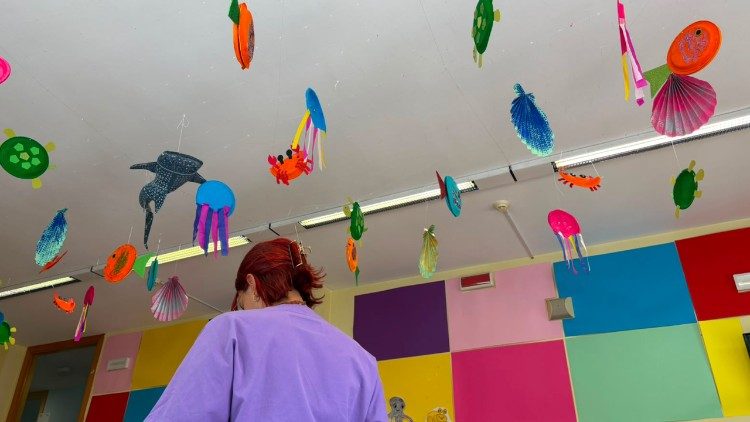 A nurse stands under the paper sea creatures
