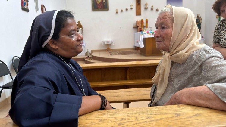 Sister Liji Paiapilli listens to an elderly Ukrainian woman at the parish in Kherson