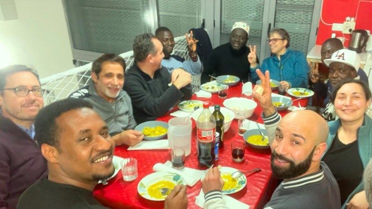 Membros do centro de acolhimento e da comunidade mission&aacute;ria re&uacute;nem-se para o jantar