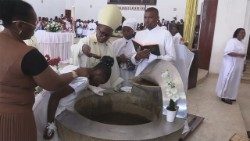 Archbishop Inácio Saúre, baptising a young lady, during Easter Mass in Nampula