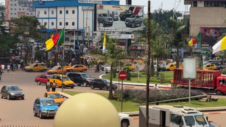 Cameroonian and Vatican flags fly at a roundabout in Yaoundé