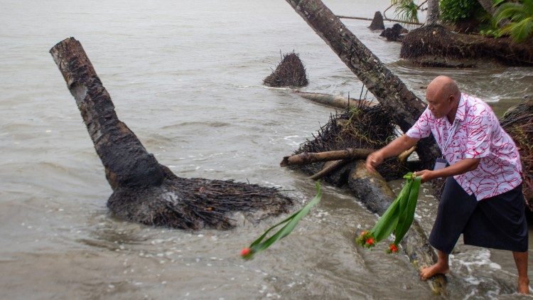 Un partecipante getta in acqua un mazzo di fiori rossi, come parte di uno degli atti simbolici della cerimonia. Foto: Marcelo Schneider/Cec