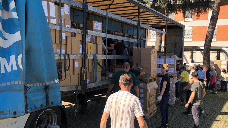 Volunt&aacute;rios carregam a ajuda do Papa.