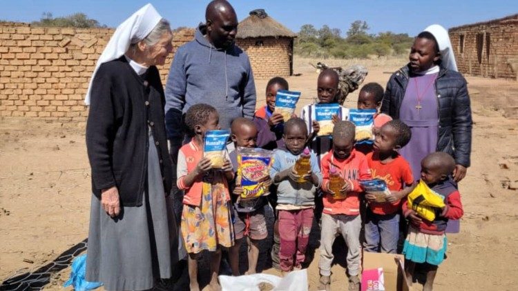 Sr. Ludbirga Schumacher and Sr. Felistar Dube distributing food in the village