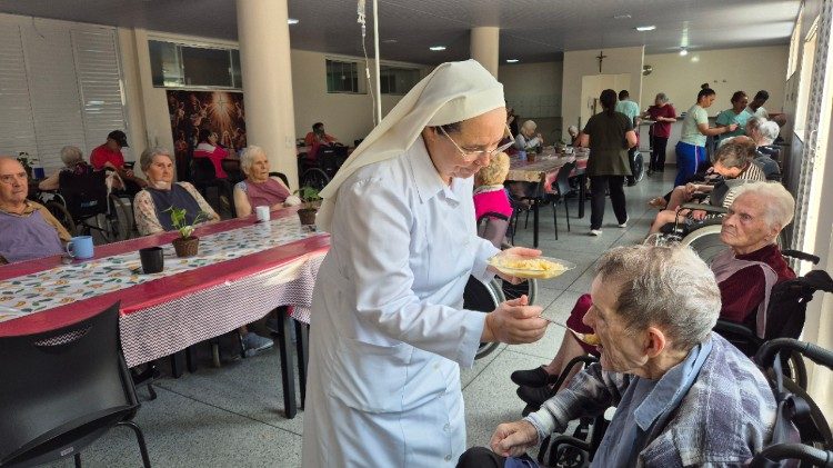Ir. Denise ao ajudar um idoso na refei&ccedil;&atilde;o