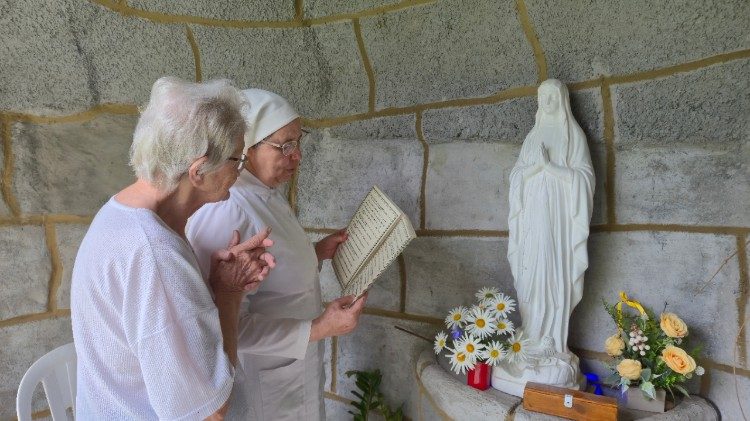 Ir. Denise e a idosa Lourdes rezam diante da imagem de Nossa Senhora