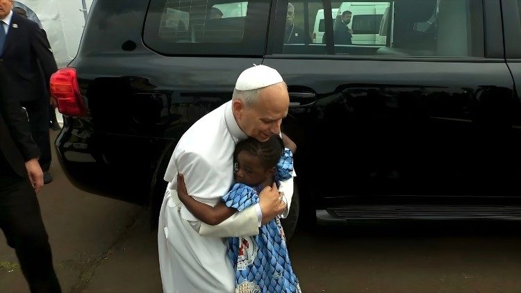 L&eacute;on XIV prend une petite fille dans ses bras lors d'une messe au Cameroun.