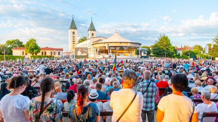 La recita serale del Rosario davanti all'altare all'aperto del santuario della Madonna Regina della Pace a Medjugorje