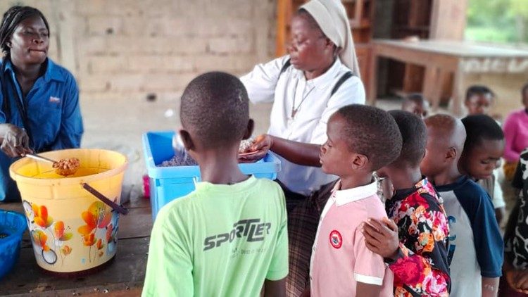 Sor Nicole distribuye la comida a los peque&ntilde;os hu&eacute;spedes del centro, por Mboma Enzenze Nicole